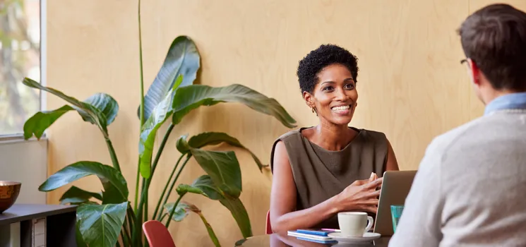 A business professional with coffee having a meeting